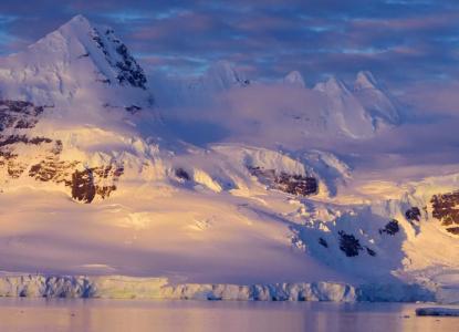 Snow-covered mountains in the background at sunrise in Antarctica