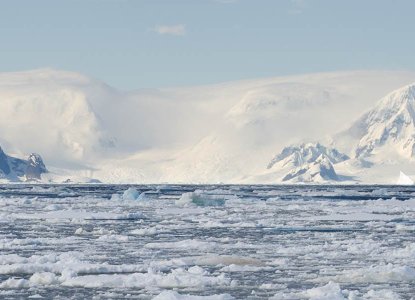 Frozen waters of Antarctica with snowy mountains in background