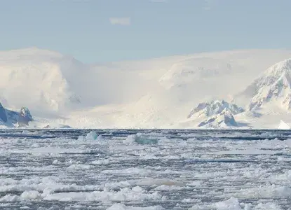 Bay filled with brash ice with snowy mountains of Antarctica in background