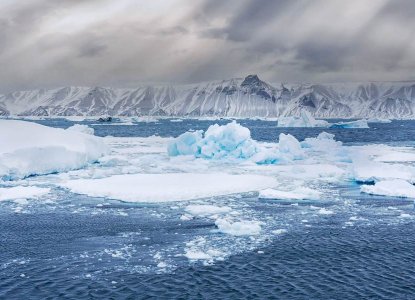 Aerial view of icebergs in the Weddell Sea and snowy mountains of the Antarctic continent